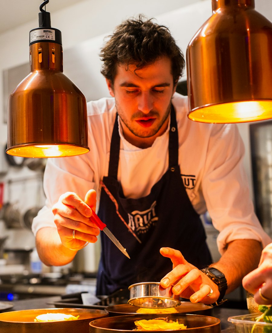 Chef plating dishes in a busy restaurant kitchen
