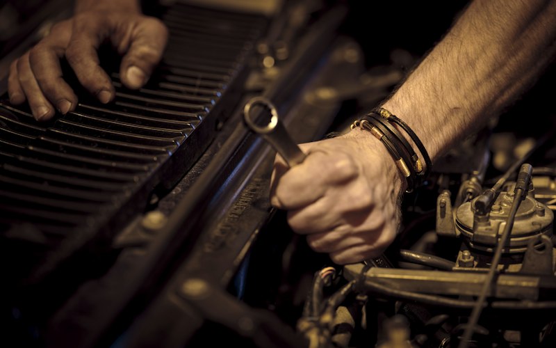 Mechanic’s hands using a wrench on a car engine